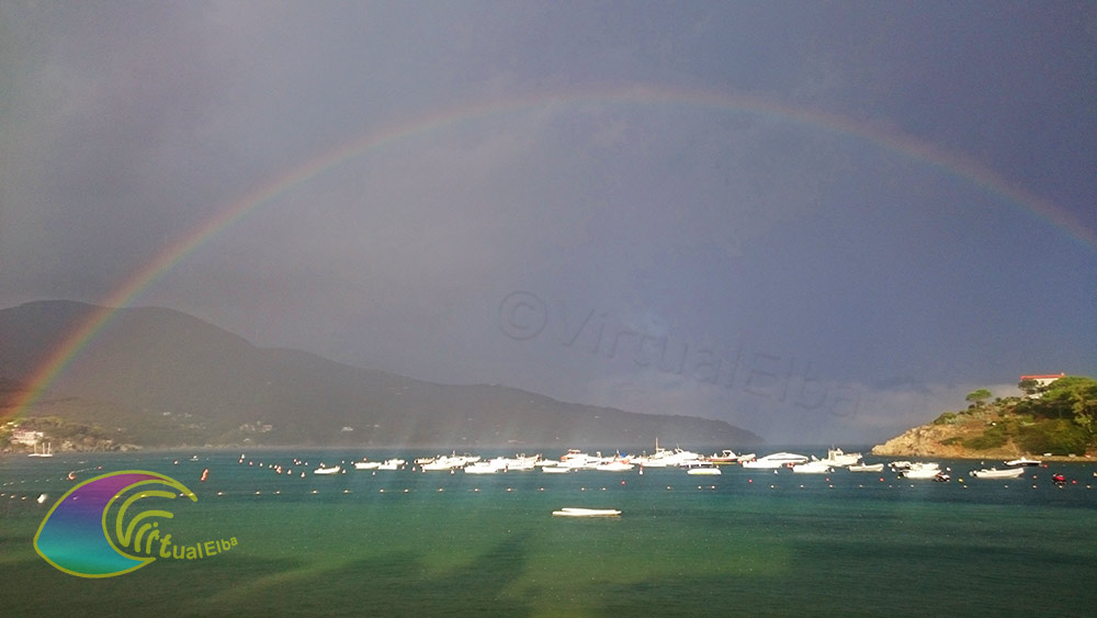 De regenboog omhult de Golf van Procchio