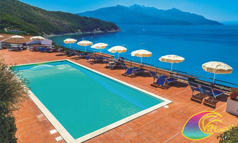 Het zwembad van het hotel met een panoramisch uitzicht op de baai van Viticcio Enfola